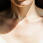 Angelina Jolie revealing mastectomy scars with gentle glow and soft cream blouse expressing strength