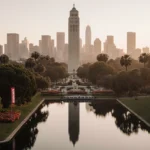 California Tower stands beside tranquil lagoon at dawn with Balboa Park green and San Diego skyline