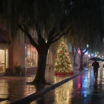 Shoppers dash down drizzly sidewalk with umbrellas blown inside out and flickering Christmas tree lights.