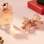 Gift table displays rose gold hair clip with bows and sleek perfume bottle under warm glow