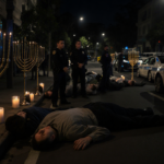 Eleven victims lying on pavement with Hanukkah candles and watchful police officers nearby