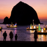 Boats glide past Morro Rock with LED lights and Christmas snowmen in Morro Bay boat parade