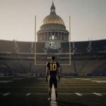 Lone figure in Fighting Irish gear standing on the 50-yard line with Notre Dame Stadium and a dome in the background