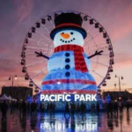 Snowman illuminates evening with LED lights and orange face while Pacific Park sign glows.