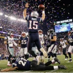 Drake Maye celebrates a touchdown pass as confetti explodes and a Ravens defender lies on the turf