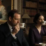 Prince Andrew sipping tea with Ghislaine Maxwell in a dim study with books and a faded Queen portrait