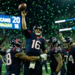 Players huddle as C.J. Stroud throws the ball with scoreboard showing Houston Texans 20 Chargers 16 and confetti in crowd