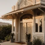 1920s Art Deco home glows with ornate trim and potted plants near lush Altadena mountains