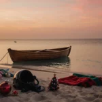 Abandoned rowboat floats on sunset lagoon with Christmas decorations and scuba helmet on empty beach