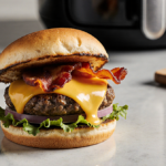 Juicy air fryer cheeseburger on a countertop with melted cheese oozing and crisp bacon warm lighting highlights tasty colors