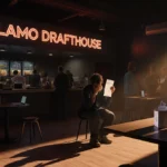 Frustrated moviegoer holds ticket with empty concession counter showing Alamo Drafthouse logo and digital ordering signs
