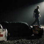Alex Pretti lying on ground with medical bag in foreground and blurred border patrol agent walking away under spotlight