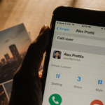 Phone screen showing last call log with parents with dim golden glow and blurred nostalgic family photo album in background