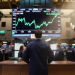 Trader watches Amazon stock surge on NYSE screen with morning light and bustling floor behind