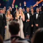 Amy Poehler holds her Golden Globe award with diverse TV winners and cheering audience behind her
