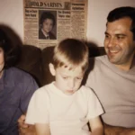 A young boy sits uncomfortably on his father