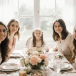 Family members gathering around a dining table with pastel flowers and family heirlooms