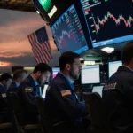 Anxious traders frantically typing on laptops with Bitcoin prices crashing on screens and US EU flags behind