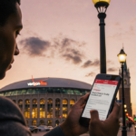 Person standing confidently near streetlamp with phone showing Verizon Fios router article title and Boston skyline