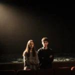 Two teenagers stand with crossed arms beside Brandon