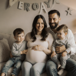 Brittany Miller sits on couch with husband and twin toddlers beside her in a warm joyful family moment.