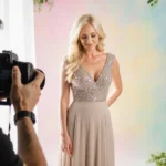 Candy Spelling posing gracefully with elegant gown and flowers while photographer captures the moment