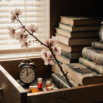 Cherry blossom branch stretching out from a dresser drawer with medical journals and prescription pills