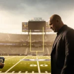 Coach confronting security guard with badge while stadium lights glow over football field