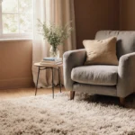 Cozy reading nook with plush armchair and neutral area rug bathed in natural light from large window