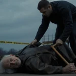 Forensic investigator lifting worn leather jacket from elderly man