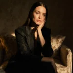 Crystal Minkoff sits alone in dimly lit Beverly Hills room with golden light and opulent furniture