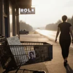 Dog walker stands beside old shopping cart with cryptic list and Polaroid showing man near highway and forest
