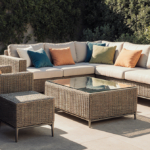 Patio set sits around a glass table with green throw pillows.