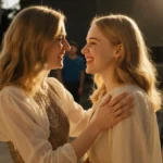 Elle and Dakota Fanning laughing together on set with film crew behind them