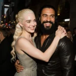 Emilia Clarke hugs Jason Momoa backstage with warm lighting showing their smiles and NYC venue crowd