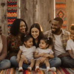 College student studying at desk with laptop and coffee surrounded by books and notes.