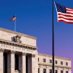 Federal Reserve building stands with American flag waving and dusk sky showing purple blue gradient