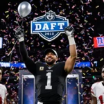 Las Vegas Raiders player holding No. 1 overall pick with confetti and balloons swirling around stadium backdrop