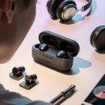 Person wearing futuristic earbuds with transparent mesh and wireless charging pads surrounded by instruments and vinyl record