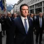 California Governor Gavin Newsom standing alone on a crowded street in Davos, Switzerland.
