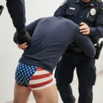 Immigrant advocating for reform sits near stack of deportation documents with worn-out papers scattered around