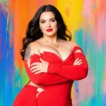 Ilona Maher stands confidently in red gown with microphone and bold colorful backdrop