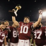Fernando Mendoza holds the Heisman Trophy with Indiana football team celebrating their national championship victory under go