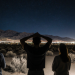 People raise hands to shield themselves from debris with San Jacinto Mountains Palm Springs in valley.