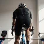 Rider cycling on a Tacx Neo 2T indoor bike trainer with natural light streaming from a window in a minimal modern home gym