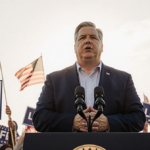 Vice President JD Vance speaking at podium with flags bearing patriotic colors and Life logos in crowd
