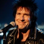 John Lydon performing with spiky hair and leather jacket with studs at mic under city lights