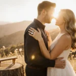 Jules Latimer and Kat Cunning embracing with engagement rings showing against golden hills and wildflowers