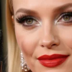 Kate Hudson poses at the Golden Globes with bold red lipstick and long lashes framed by shimmery eyeshadow