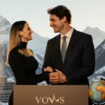 Katy Perry and Justin Trudeau stand at podium with hands clasped against a mountain backdrop and Davos Congress Centre window